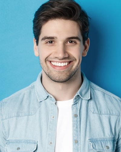 close-up-young-successful-man-smiling-camera-standing-casual-outfit-against-blue-background close-up-young-successful-man-smiling-camera-standing-casual-outfit-against-blue-background